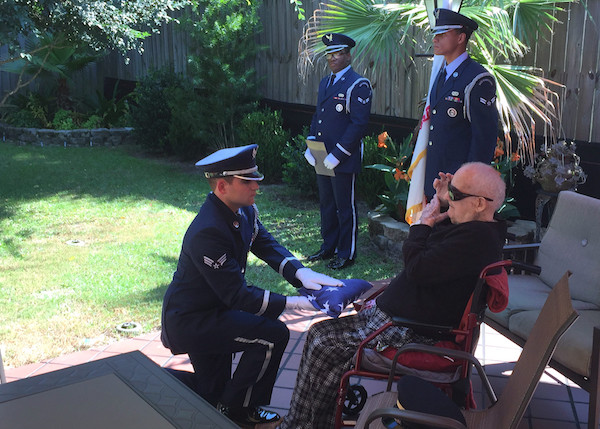 The Eglin Air Force Base Honor Guard presents 100-year old WWII veteran Herbert Clippinger with his honorary flag.